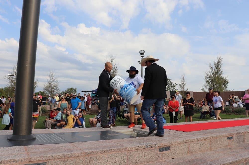 Mayor Travis Mitchell and Council Member Robert Rizo present the time capsule. (Zara Flores/Community Impact Newspaper)