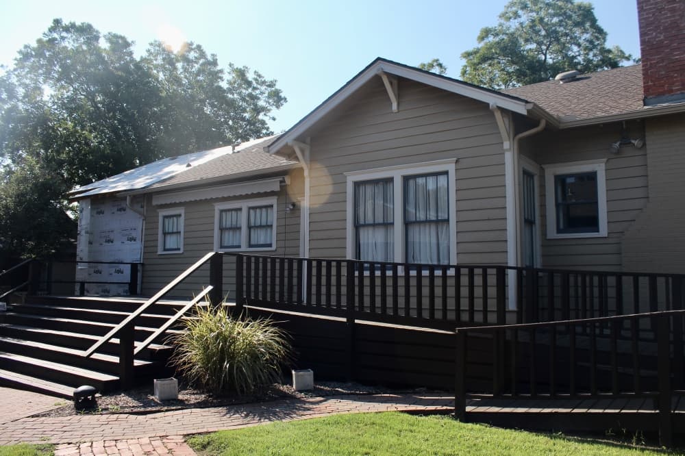 Back to historic Bevel House at Chestnut Square with a deck and visible construction elements of the renovation.