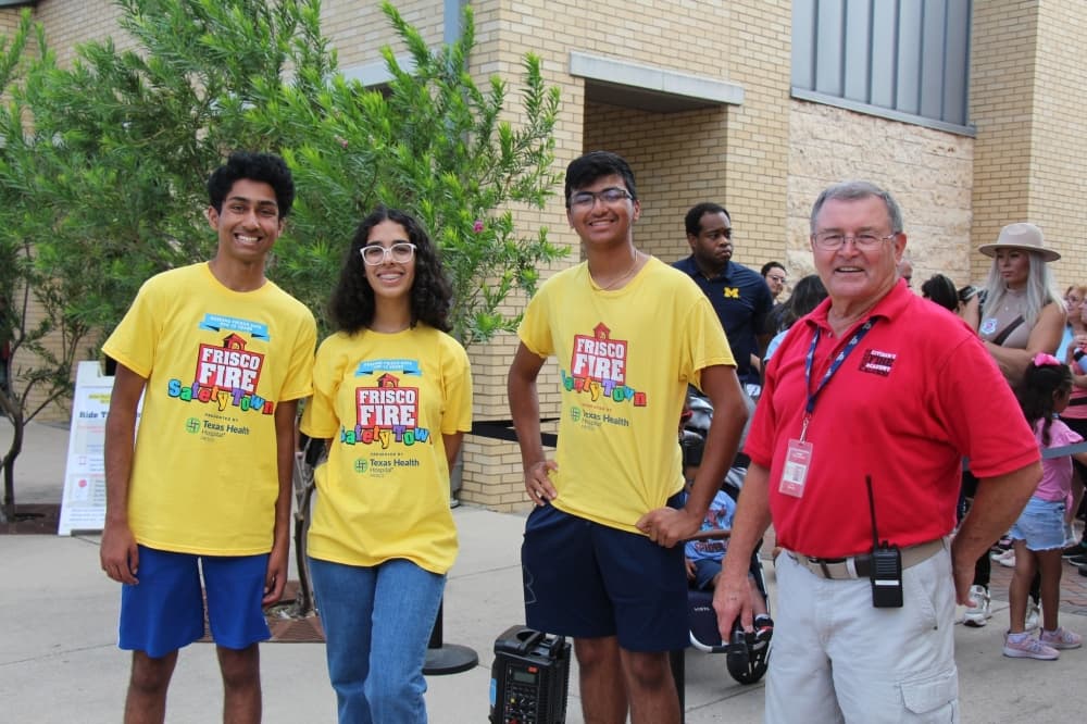 Group of 3 teen volunteers and one Safety Town employee smiling.