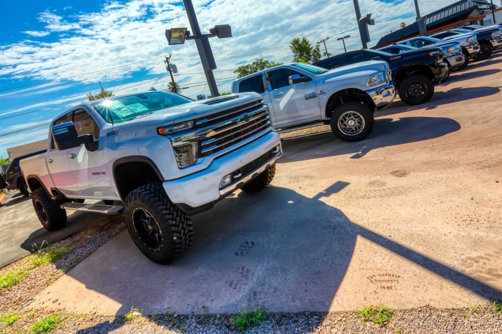Skewed perspective of a row of trucks at a dealership.
