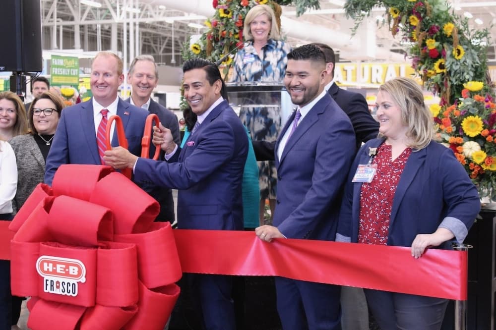 H-E-B General Manager El Daniel holds the scissors to cut the ribbon on the first H-E-B grocery store in Dallas-Fort Worth in Frisco. (Colby Farr/Community Impact Newspaper)