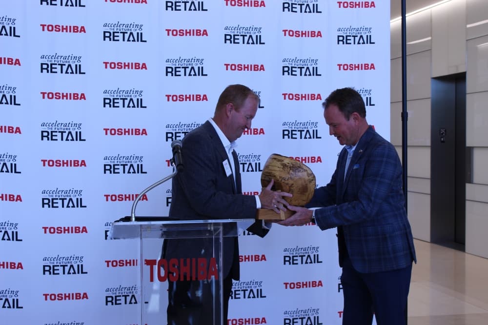 Frisco Mayor Jeff Cheney presents an official pecan bowl as a token of appreciation and a symbol of the city’s relationship with Toshiba Global Commerce Solutions. (Colby Farr/Community Impact Newspaper)