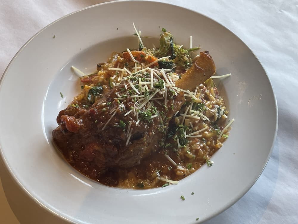 Braised lamb shank is served with vegetable risotto, $18.95. (Taylor Cripe/Community Impact Newspaper)