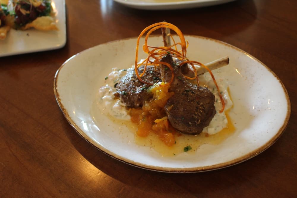 Tandori lamb lollipops ($17) includes serrano apricot chutney paired with cucumber raita. (Peyton MacKenzie/Community Impact Newspaper)