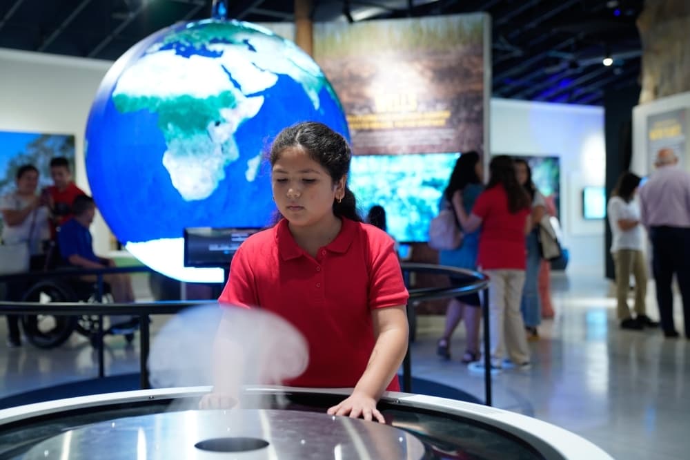 A student learns about water and the formation of clouds using the Cloud Caster at the Education Outreach Center. (Courtesy Edwards Aquifer Authority)