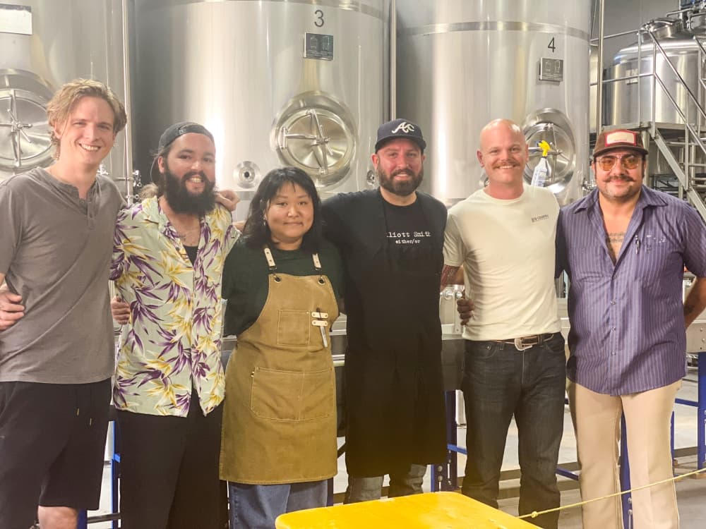 brewery workers in front of fermenter