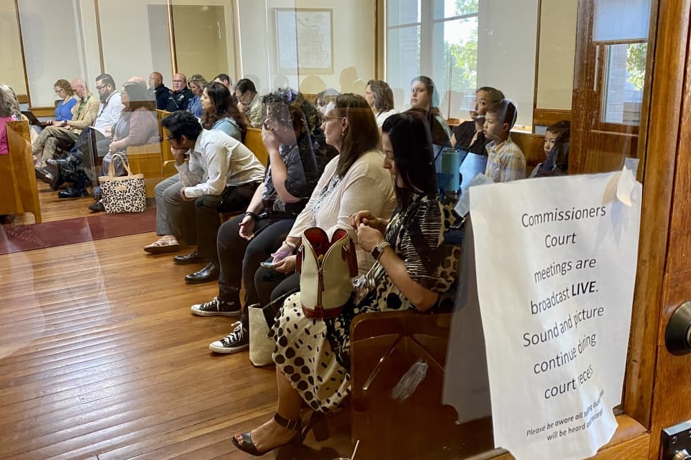 People sitting and looking towards the front of the room. 