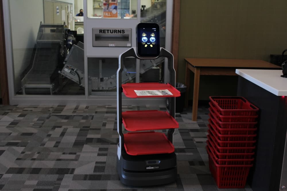The library robot in dance mode with a cartoon face on the screen