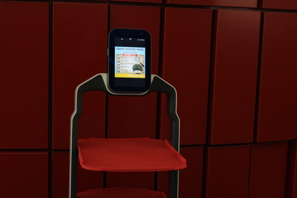 Robot in holding pattern showing a library program advertisement on the screen