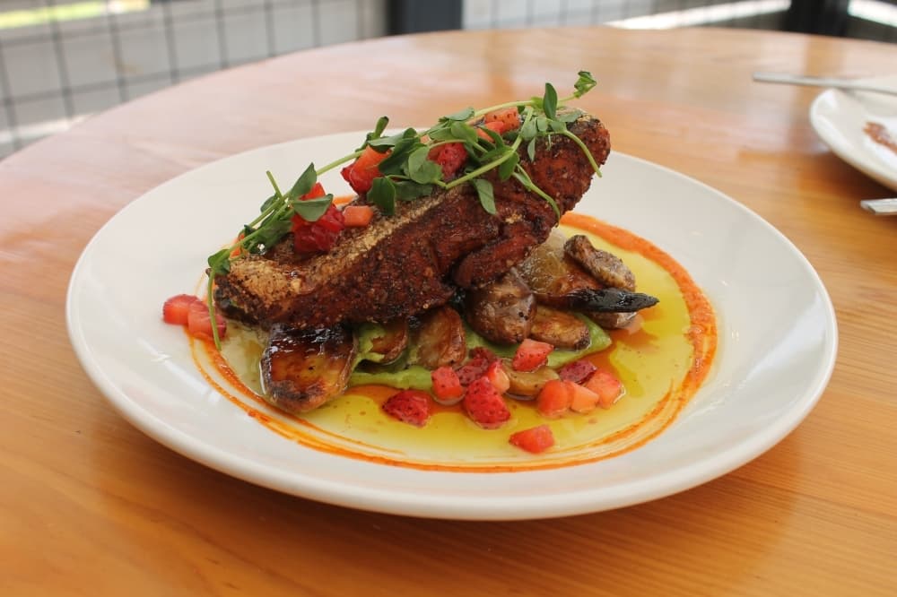Crispy pan-seared salmon ($28): Seven ounces of house-cut salmon are served with fingerling potatoes, wasabi pea puree, summer plum gastrique, spicy harissa and pea shoots. 