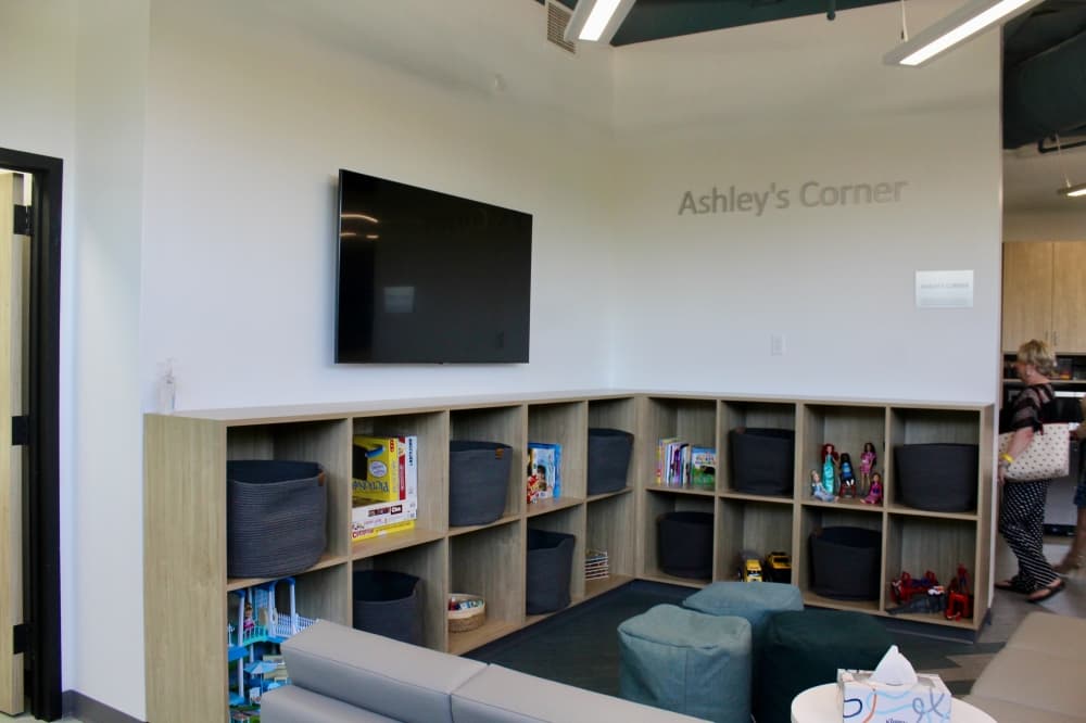 Ashley's Corner with a tv, sofa and toys.