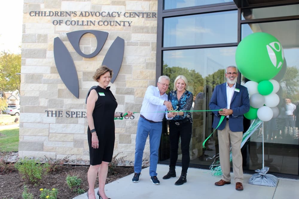 Mark and Carolyn Speese cutting a ribbon that Lynne McLean and Dan Powers are holding.