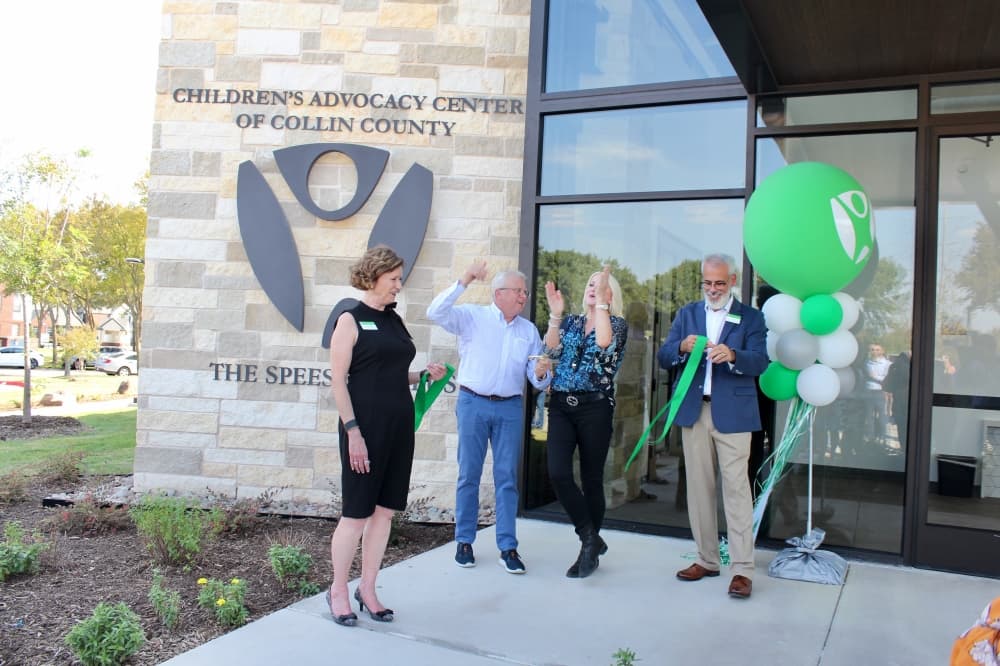 Mark and Carolyn Speese cutting a ribbon that Lynne McLean and Dan Powers are holding.