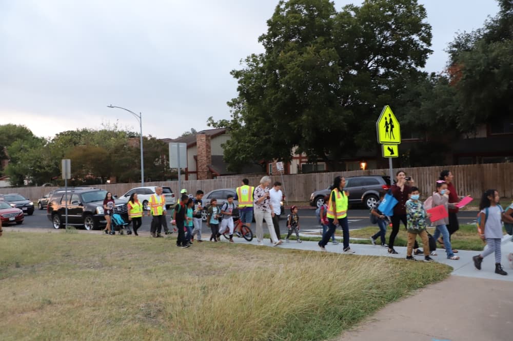People walking in a line on a sidewalk