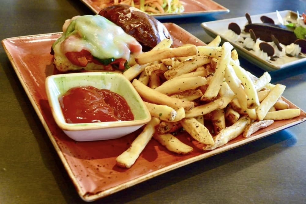 Brix chicken sandwich: This take on the classic chicken sandwich is a grilled chicken breast topped with sauteed spinach, roasted tomatoes and melted provolone cheese on a pretzel bun and is served with fries. ($15) (Hunter Terrell/Community Impact) 