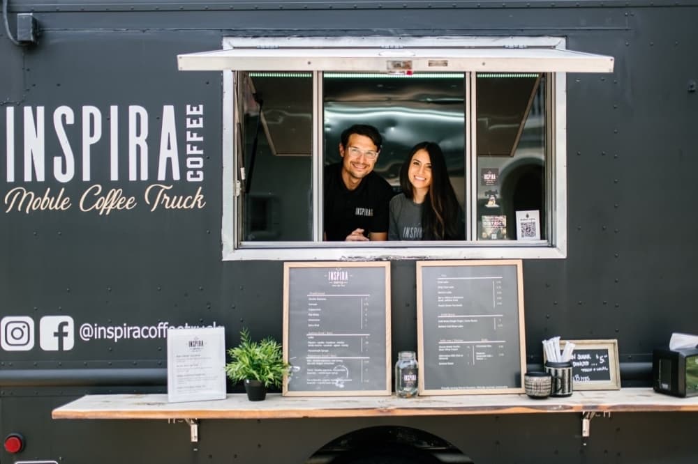 Justin and Corinna Valdez at the service window of their repurposed FedEx delivery truck-turned mobile craft coffee shop. 
