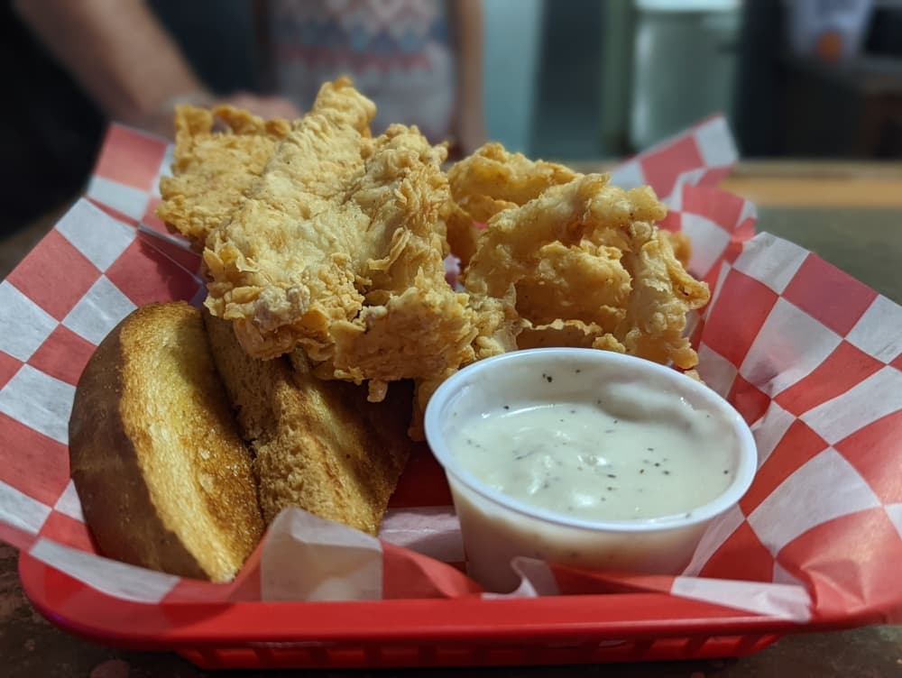 Chicken tenders ($11.75) come with fries and cream gravy and are a regular on the eatery’s menu. Onion rings are an additional $1.25. (Jishnu Nair/Community Impact Newspaper)