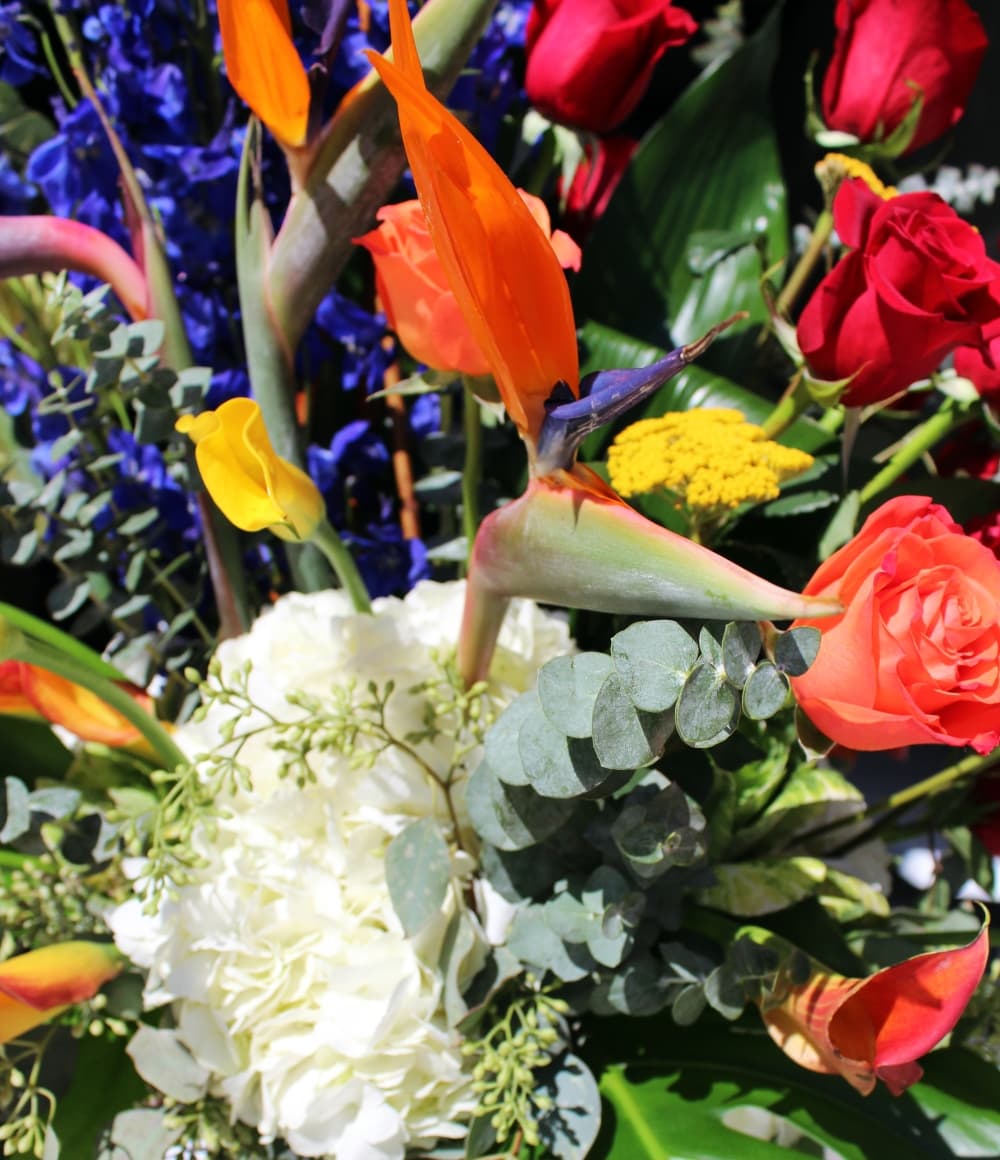This custom arrangement features a myriad of flowers, including chrysanthemums, yellow yarrow, birds of paradise, blue delphinium and bamboo. (Karen Chaney/Community Impact)