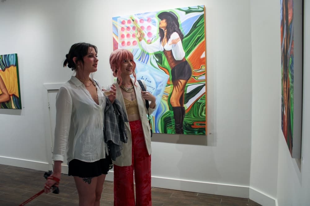 Two women looking at paintings