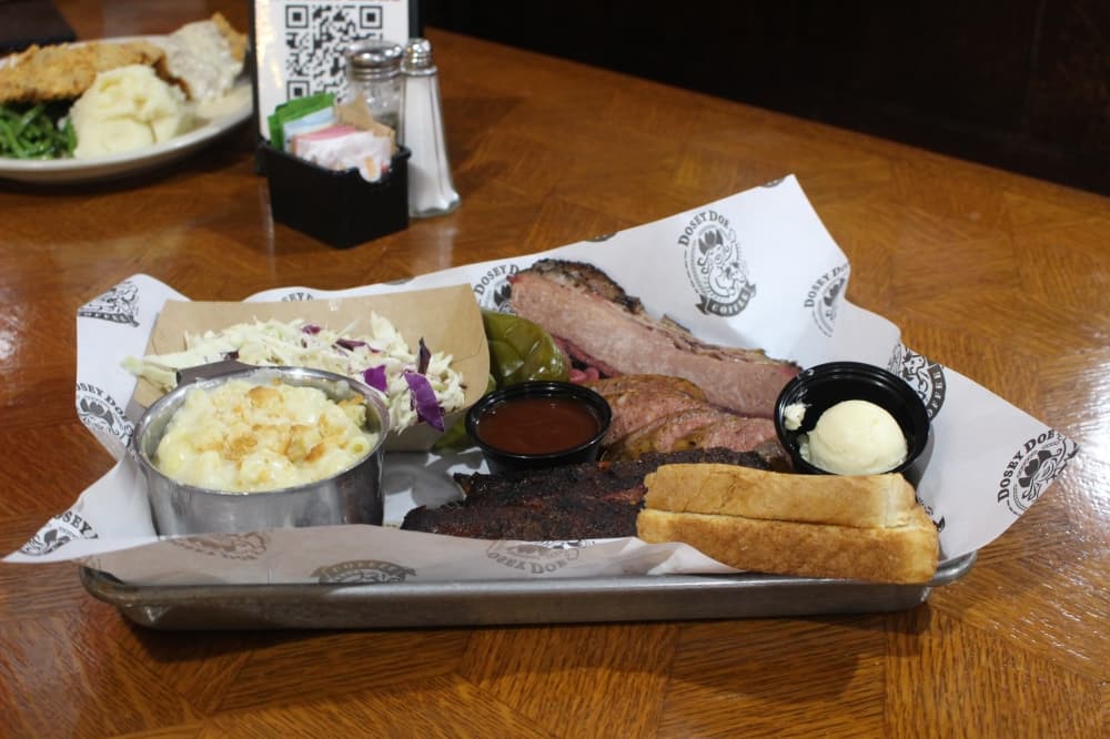 The Texas Trinity plate ($24.99) is made up of brisket, ribs, a choice of sausage and two sides served with Texas toast and pickled vegetables. (Kylee Haueter/Community Impact)