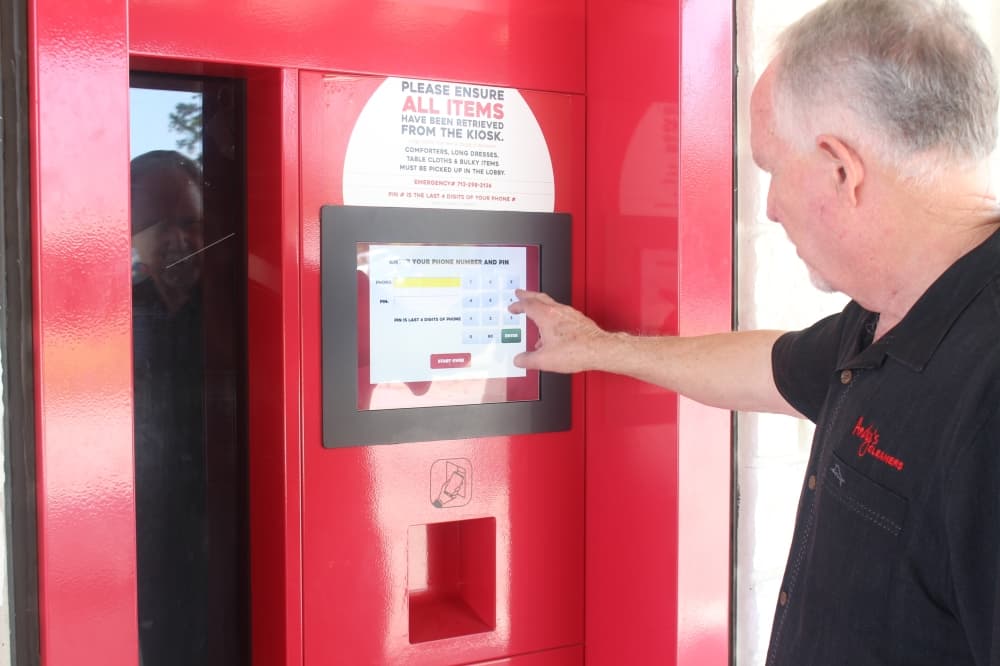 Co-owner Paul Zeck demonstrates how to use Andy’s Cleaners 24-hour kiosk. (Andrew Christman/Community Impact)