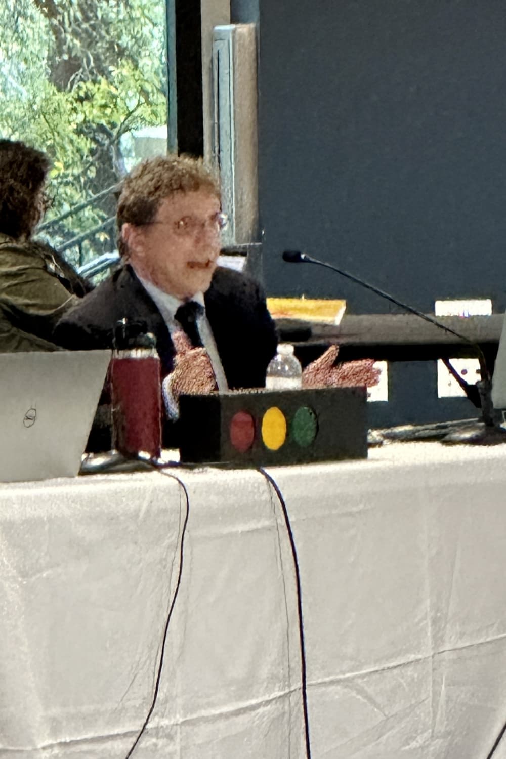 Man sitting and speaking on a mike.
