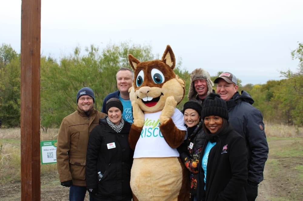 Frisco City Council members pose with Walnut the Squirrel, Play Frisco's mascot. (Colby Farr/Community Impact)