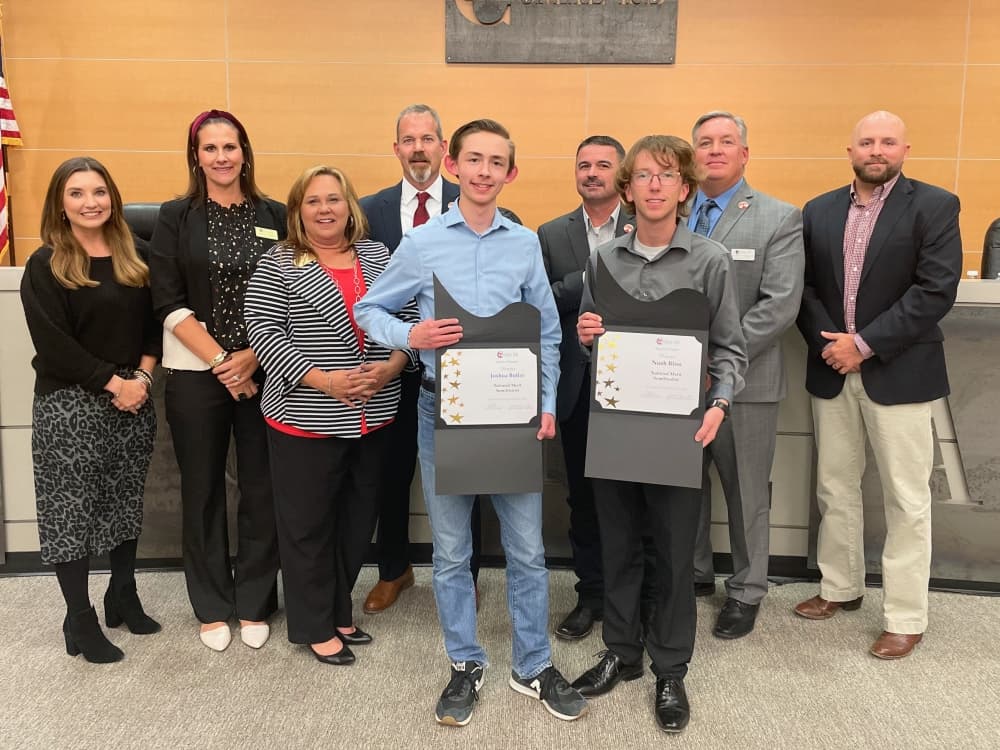 Three students from Comal ISD were named National Merit Semifinalists this year, including Joshua Butler and Noah Bliss, who are pictured with the Comal ISD board of trustees. Mason Mock, who is not pictured, also received this honor. (Sierra Martin/Community Impact)