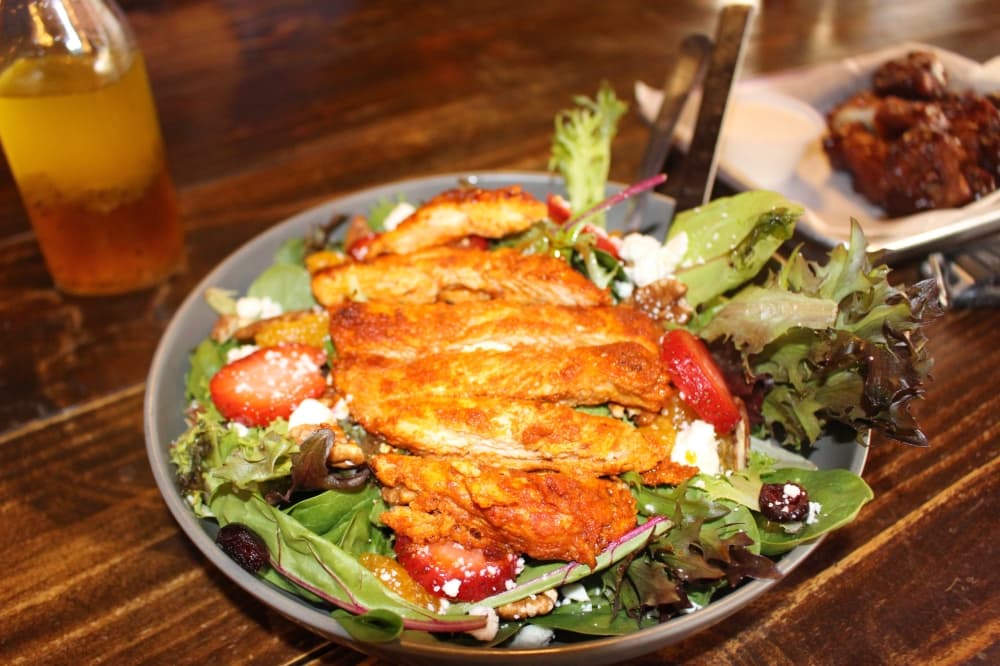 Mixed greens salad with chicken ($14.95) has feta cheese, almonds or pecans, fruit and vinaigrette dressing. (Peyton MacKenzie/Community Impact)