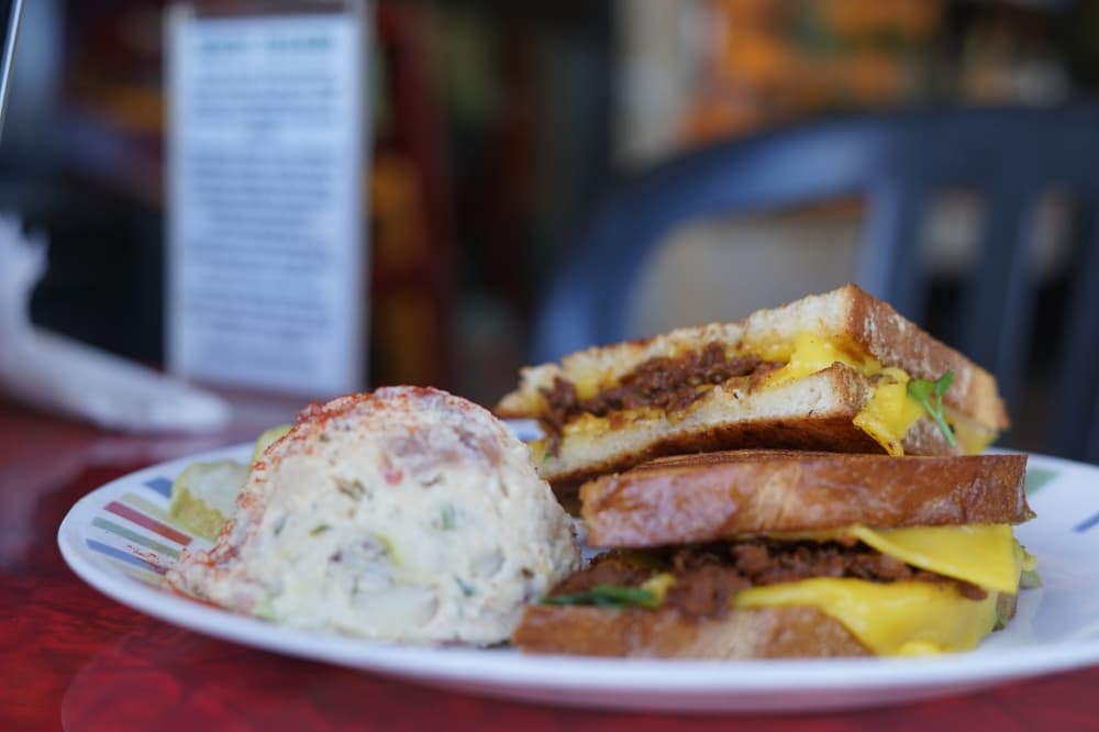 The La Doña lunch special is a sourdough grilled cheese stuffed with veggie chorizo, cilantro, red onion and charred jalapeno taqueria salsa and a side of 
potato salad. (Katy McAfee/Community Impact)