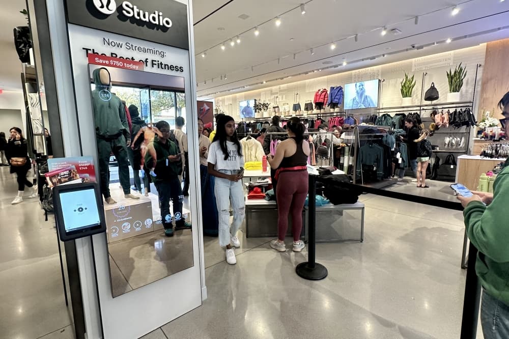 An interactive mirror with icons about exercises on display in a clothing store. 