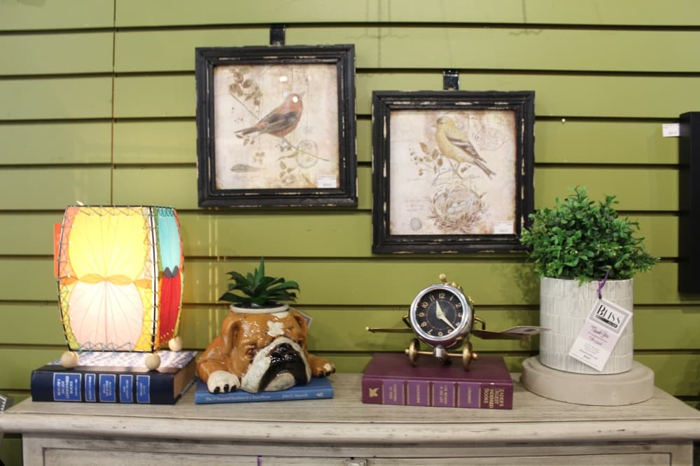 A table at Bliss on 19th features a selection of items the shop specializes in, including wall art, lamps and decorative clocks. 
