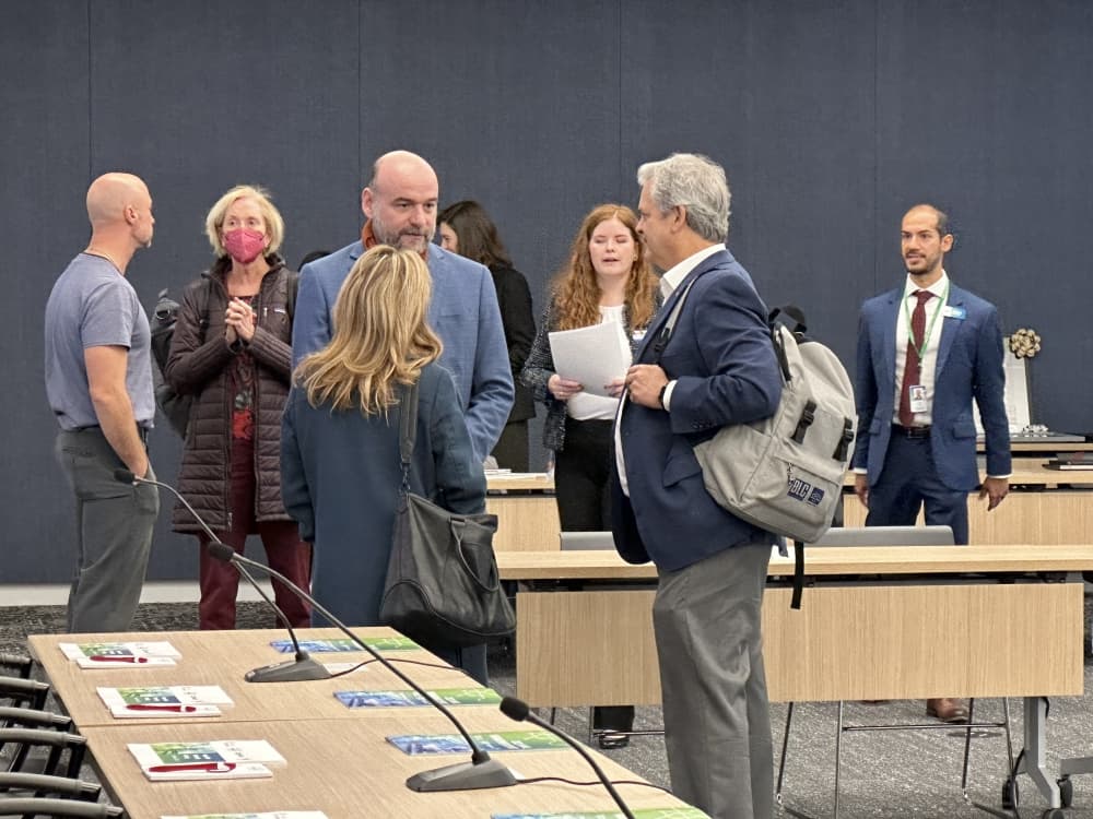 People standing and talking at a meeting