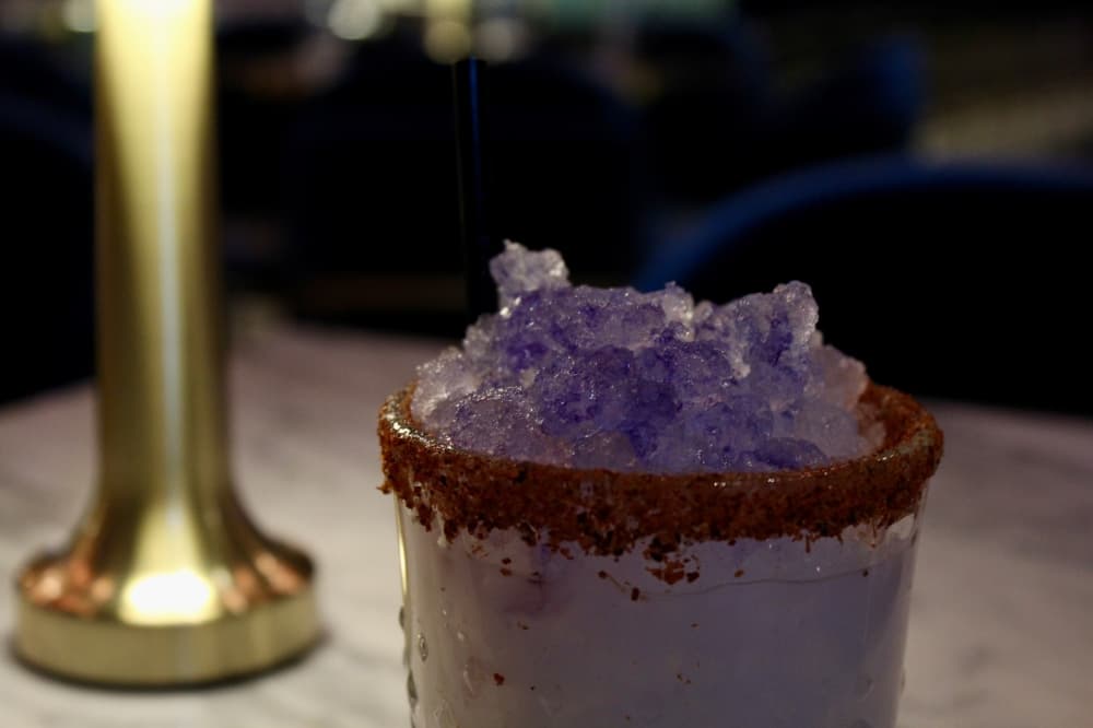 The Snowbird ($18) includes tequila, orange liqueur, coconut cream, lime juice, a Tajín rim and pea tea bitter spray. (Shelbie Hamilton/Community Impact)