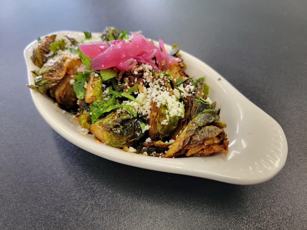 The Honey Chipotle Brussel Sprouts ($6.95) are garnished with cilantro and pickled onion.
