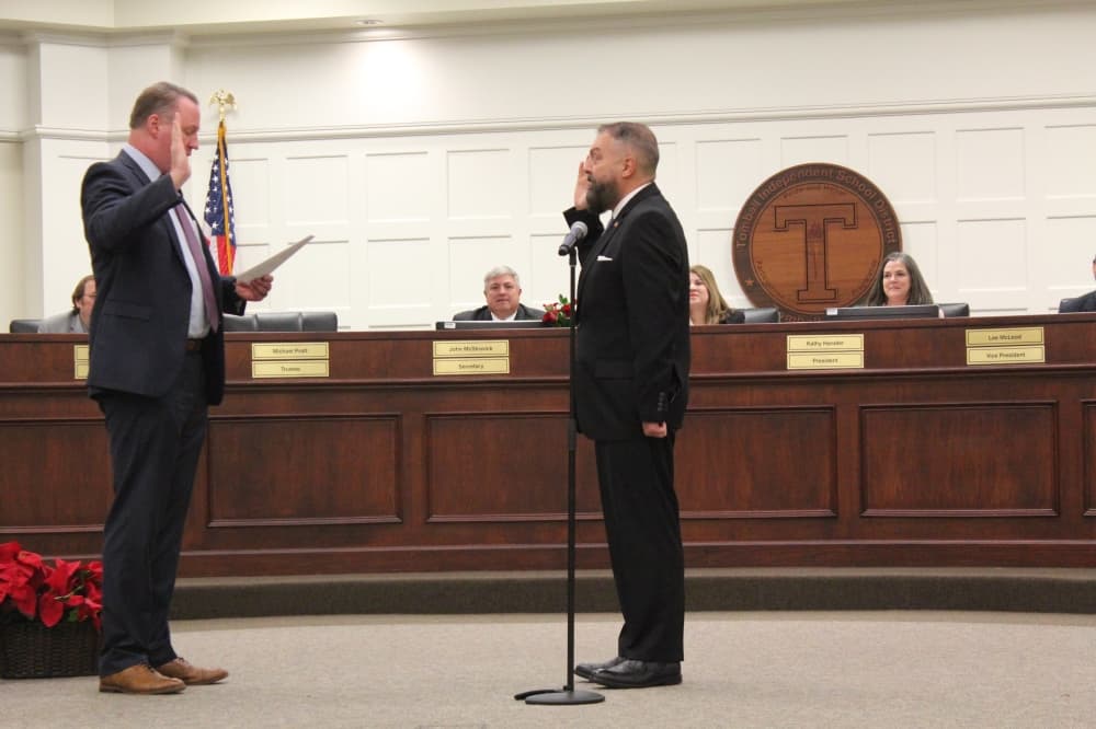 Michael Pratt (right) is sworn in Dec. 6 to another term on the board in Position 2. (Anna Lotz/Community Impact)