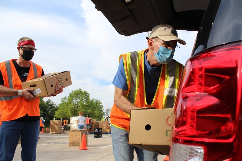 
North Texas Food Bank volunteers load boxes into a car. The nonprofit serves people throughout the metroplex.