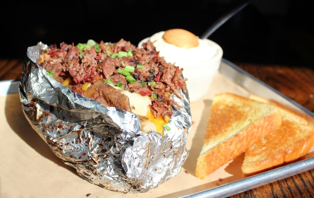 Loaded baked potato ($7) with brisket ($13). Pictured with banana pudding ($4). (Karen Chaney/Community Impact)