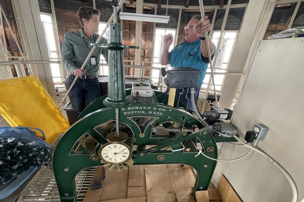 Williamson County Architect Trenton Jacobs (left) and Building Systems Engineer Daniel Shea stand with the clock. (Grant Crawford/Community Impact)