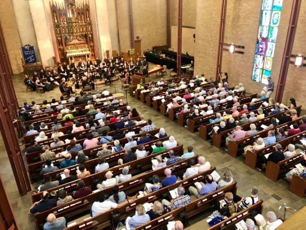 overhead shot of texas bach festival performance with orchestra in front of large group in church pews
