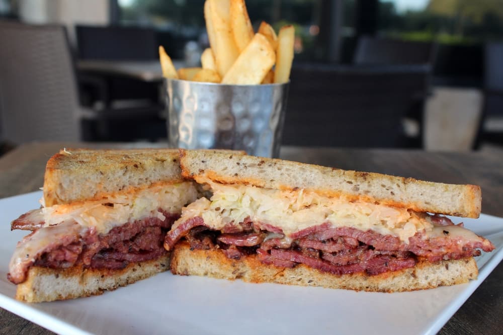 Pastrami Reuben Sandwich ($18) includes house-smoked pastrami, sauerkraut, Gruyere cheese and Russian dressing on rye bread. It is served with fries. (Karen Chaney/Community Impact)