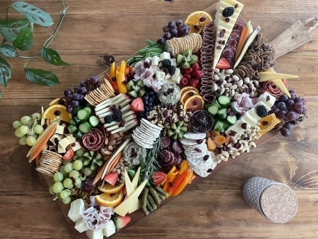 charcuterie board with meats, cheeses, crackers, dips, fruit  