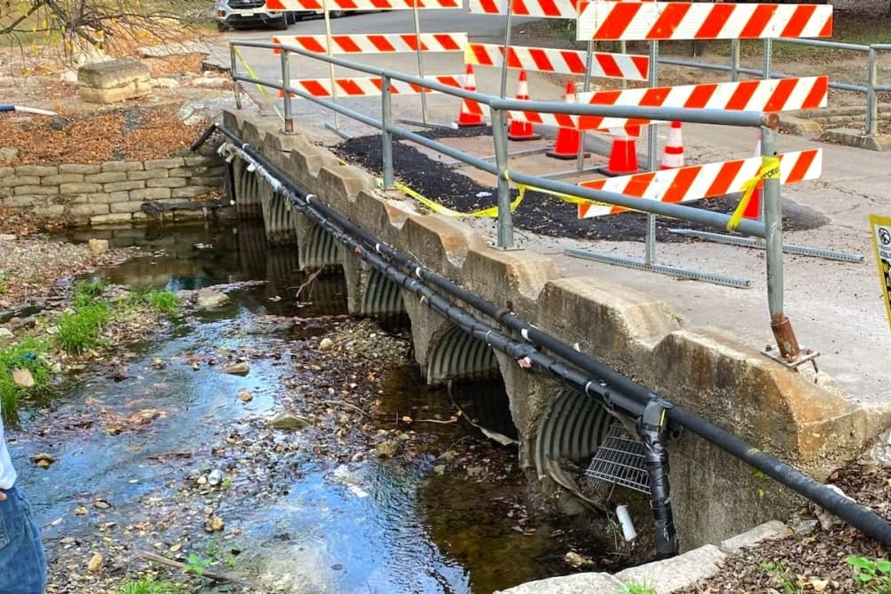 partially collapsed bridge with traffic barriers