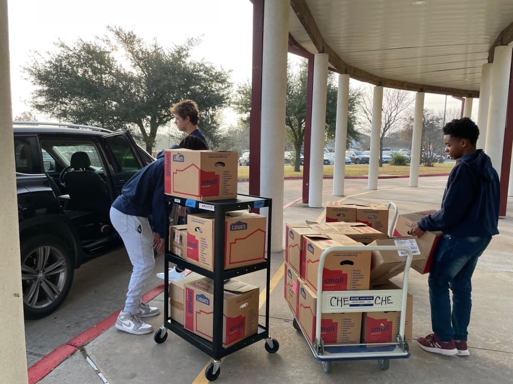 Ashenafi Baize, Bronson-James Burleson and Jack Baize helped to deliver and unload books at Caldwell Heights Elementary School. (Courtesy Kasey Baize)