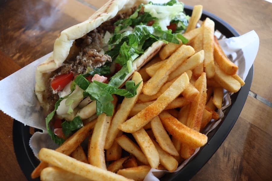 The most popular item on the menu at The Pita Shop is a Greek classic: the beef and lamb gyro is served with lettuce, tomato, tzatziki sauce and a side of fries. (Zara Flores/Community Impact)