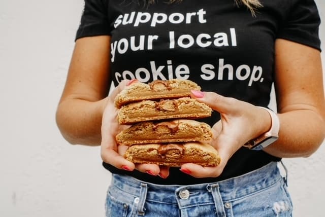 employee holding stack of cookies