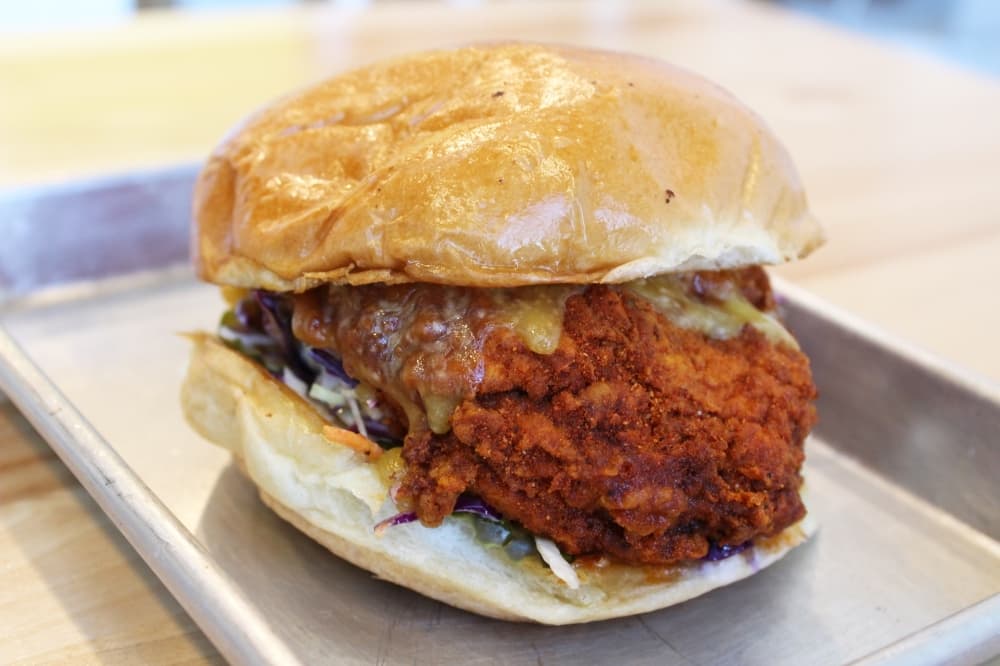 The spicy fried chicken sandwich ($12) features Nashville-style hot chicken, coleslaw, dill pickles and comeback sauce on a toasted brioche bun.  (Photo by Karen Chaney)