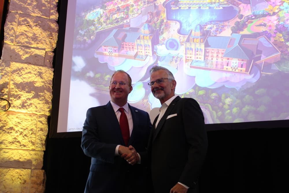 Frisco Mayor Jeff Cheney shakes hands with Mark Woodbury, chair and CEO of Universal Parks and Resorts, at a press conference on Jan. 11. (Grant Johnson/Community Impact)