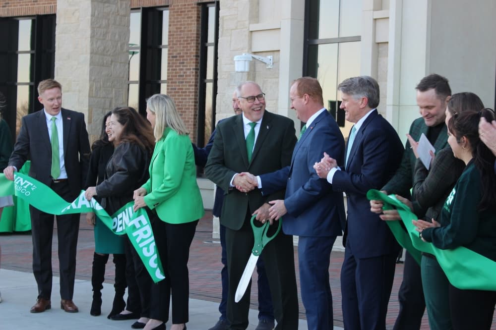 UNT President Neal Smatresk and Frisco Mayor Jeff Cheney shake hands to celebrate the opening of the new Frisco Landing campus. (Alex Reece/Community Impact)