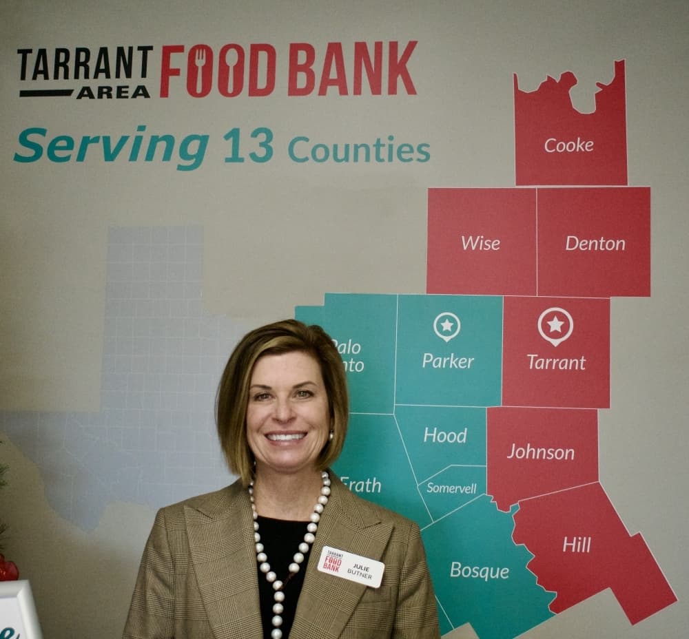 Julie Butner stands next to a map of Tarrant County. 